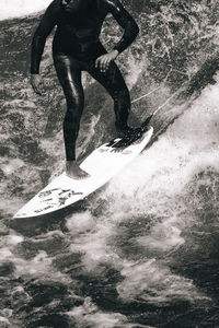 Low section of man standing in water