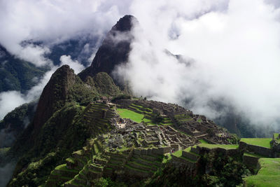 Aerial view of old ruins on mountain against cloudy sky