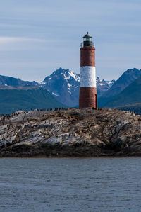 Lighthouse by sea against sky