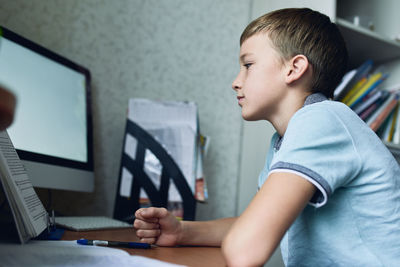 Side view of boy using computer