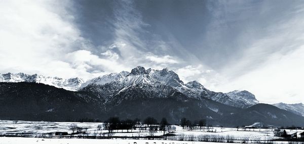 Scenic view of snow covered field and mountain against sky