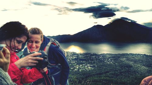 Young man photographing while looking at lake