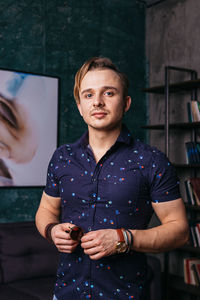 Portrait of young man holding camera