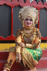 Woman wearing traditional clothing while sitting outdoors