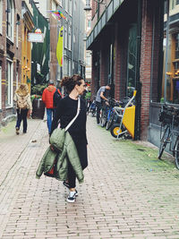 People walking on street amidst buildings in city