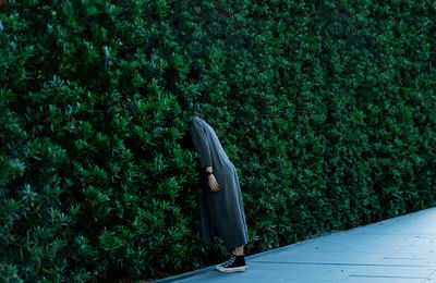 Side view of woman standing against trees