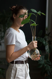 Midsection of woman holding plant