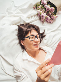 Smiling woman with bouquet of roses and letter in pink envelope.valentine day or happy birthday.