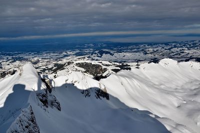 Aerial view of snowcapped mountains against sky