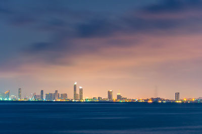 Illuminated buildings in city against sky