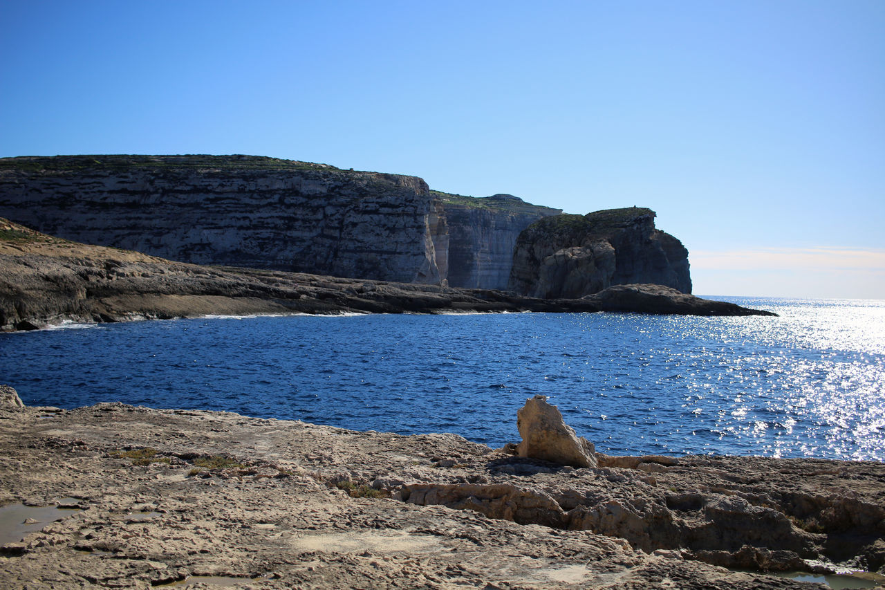 water, rock, sea, sky, coast, shore, ocean, land, beach, cliff, nature, scenics - nature, body of water, beauty in nature, clear sky, blue, bay, terrain, tranquility, no people, tranquil scene, horizon, travel destinations, wave, coastline, landscape, environment, rock formation, day, mountain, non-urban scene, outdoors, travel, animal wildlife, cove, sunny, geology, animal, animal themes