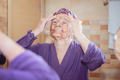 Elderly woman taking care of her face