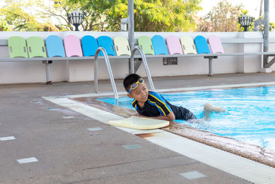 Boy sitting in swimming pool