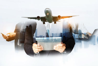 Digital composite image of man holding airplane