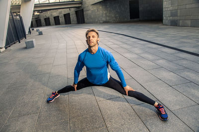 Full length of man sitting on wall