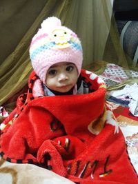 Portrait of cute baby girl lying on bed at home