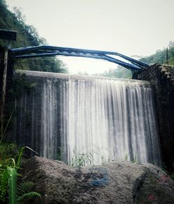 Scenic view of waterfall against sky