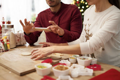 Midsection of couple preparing food at table