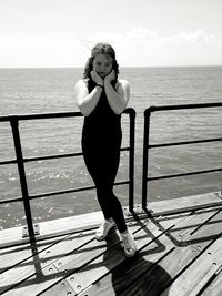 Full length of woman standing on sea shore against sky