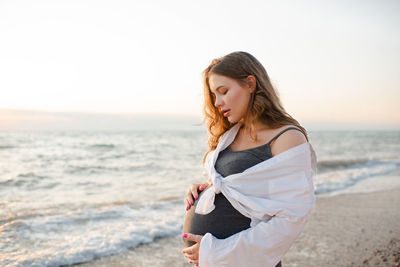Pregnant woman 20-24 year old wear casual dress and shirt over sea nature