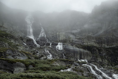 Low angle view of waterfall against rock formation