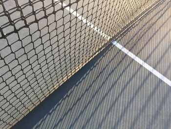 High angle view of net at tennis court during sunny day