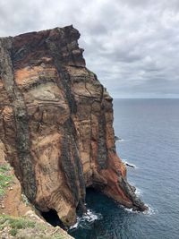 Rock formation in sea against sky