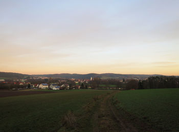 Scenic view of field against sky at sunset