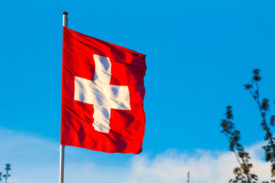 Low angle view of flag against blue sky