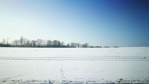 Scenic view of snow field against clear blue sky