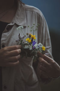 Midsection of woman holding flowers