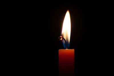 Close-up of burning candle in darkroom