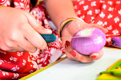 Woman cutting onions and other vegetables with a knife