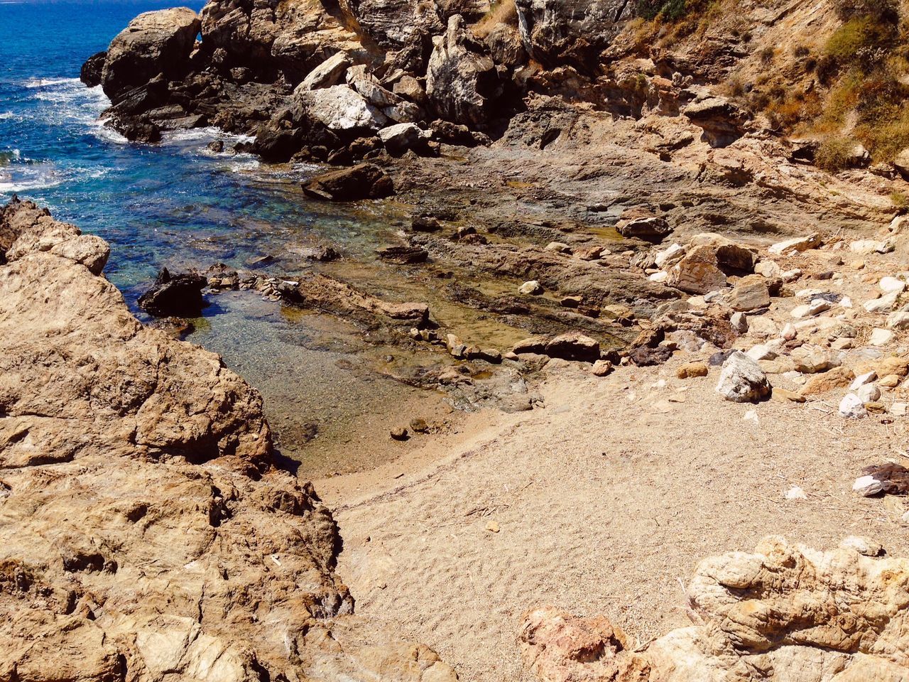 beach, water, sea, tranquility, tranquil scene, shore, rock - object, nature, scenics, beauty in nature, sand, rock formation, rock, coastline, high angle view, sunlight, day, idyllic, outdoors, no people