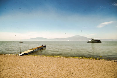 Pier over lake against sky