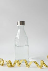 Close-up of glass bottle on table against white background