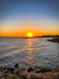 Scenic view of sea against clear sky during sunset