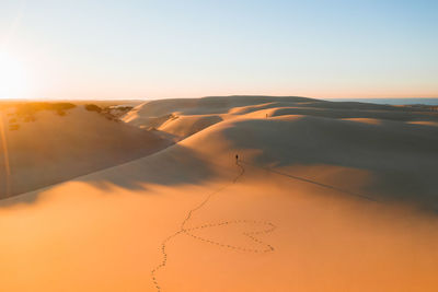 Scenic view of desert against sky during sunset