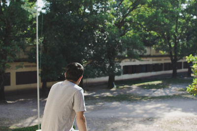 Rear view of man standing against trees