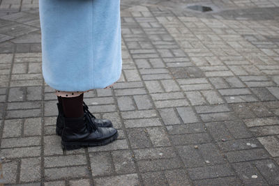 Low section of woman standing on footpath