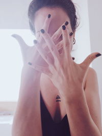 Portrait of woman covering face with hands