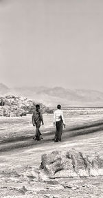 People walking on land against sky