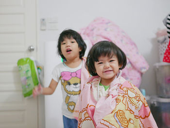 Portrait of cute sibling standing at home