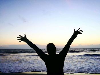 Silhouette of woman on beach at sunset