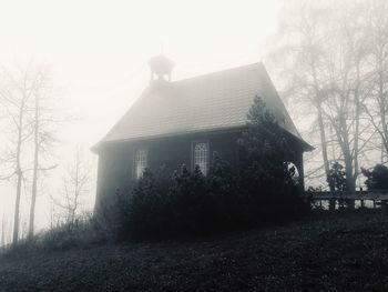 Building by trees against sky