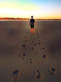 Rear view of man walking on beach