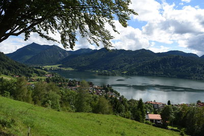 Scenic view of lake amidst mountains against cloudy sky