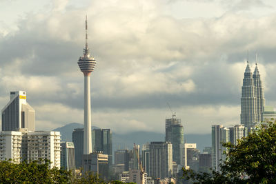 Skyscrapers in city against cloudy sky