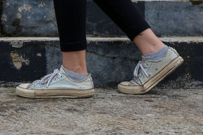 Low section of woman standing on footpath