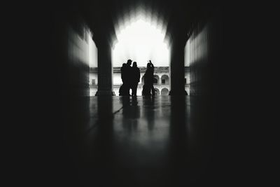 Rear view of silhouette people standing in tunnel